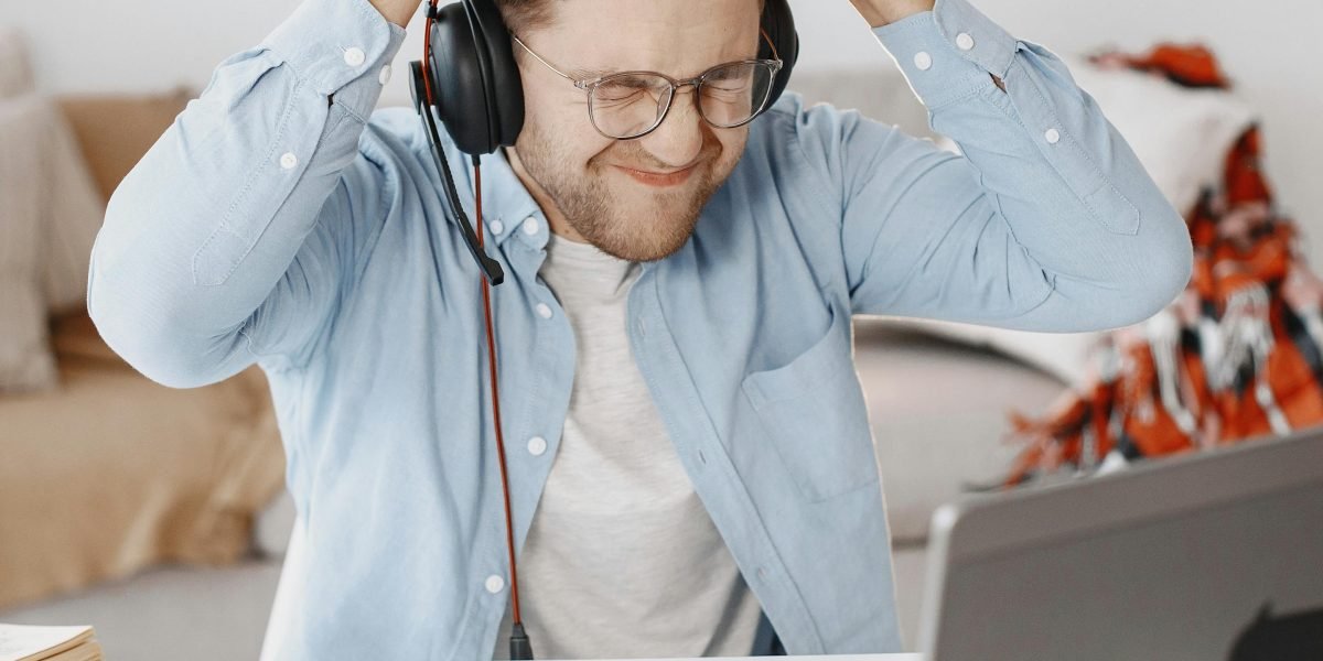 A person expresses frustration while waiting for a slow-loading video or web page, a common experience with inadequate internet speed.