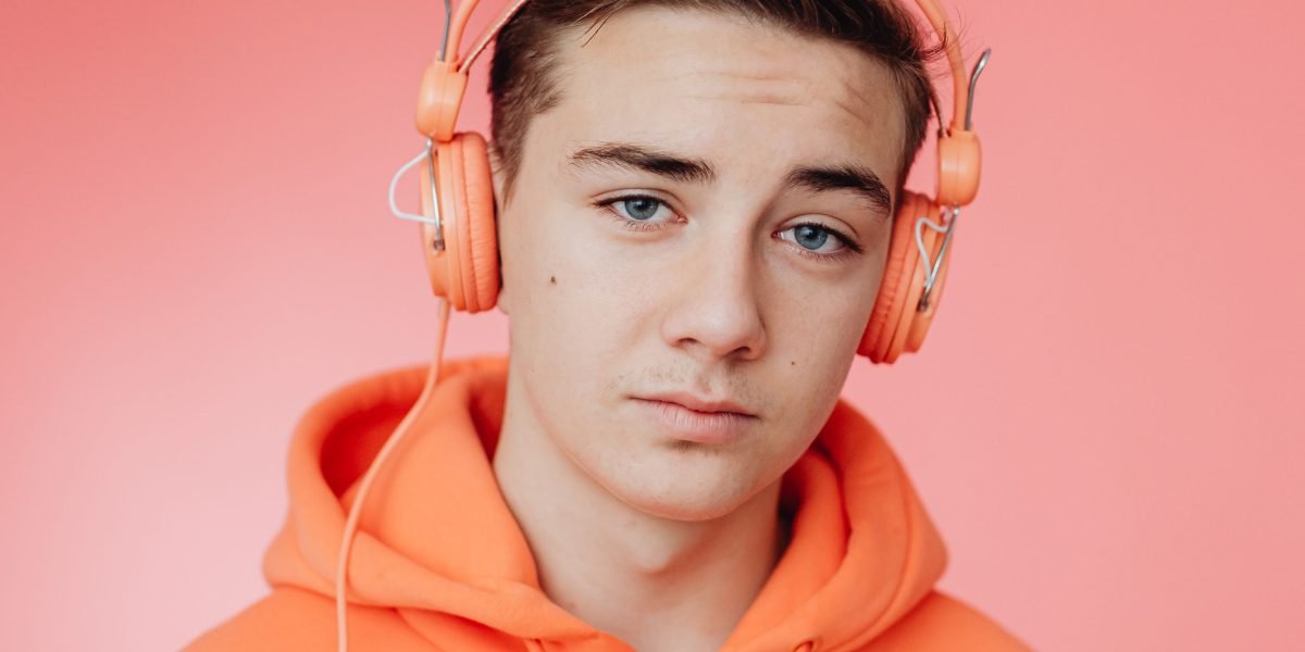 A person thoughtfully chooses the perfect music, headphones on, for a creative project.